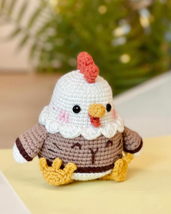 Brown and white crocheted chicken amigurumi from @rnata6744 with yellow feet and red comb for easter crochet ideas.