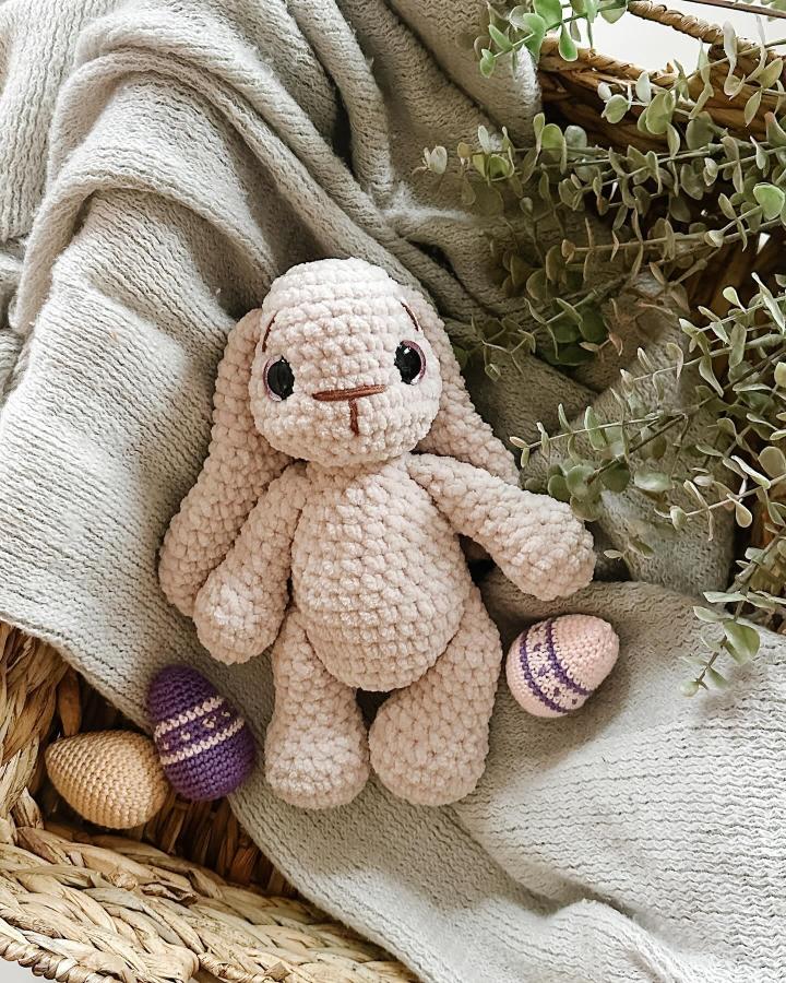 Plush cream crochet bunny with pastel crocheted eggs in basket from @tangledbykarina soft textures and gentle colors for Easter crochet ideas