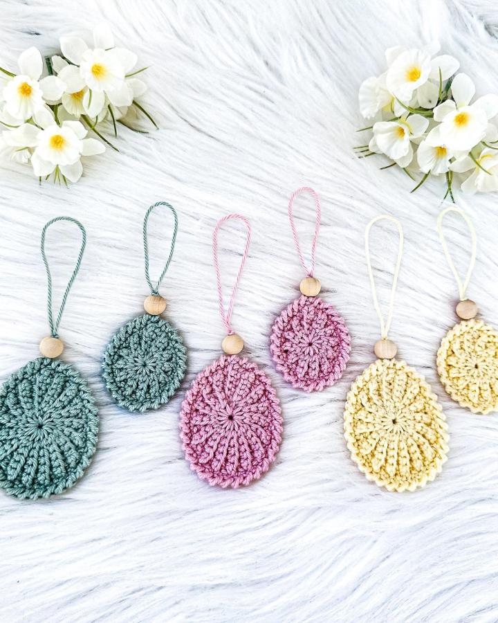 pastel crochet Easter eggs with wooden beads on white faux fur from @muffi_corn delicate and bright easter crochet ideas decorations