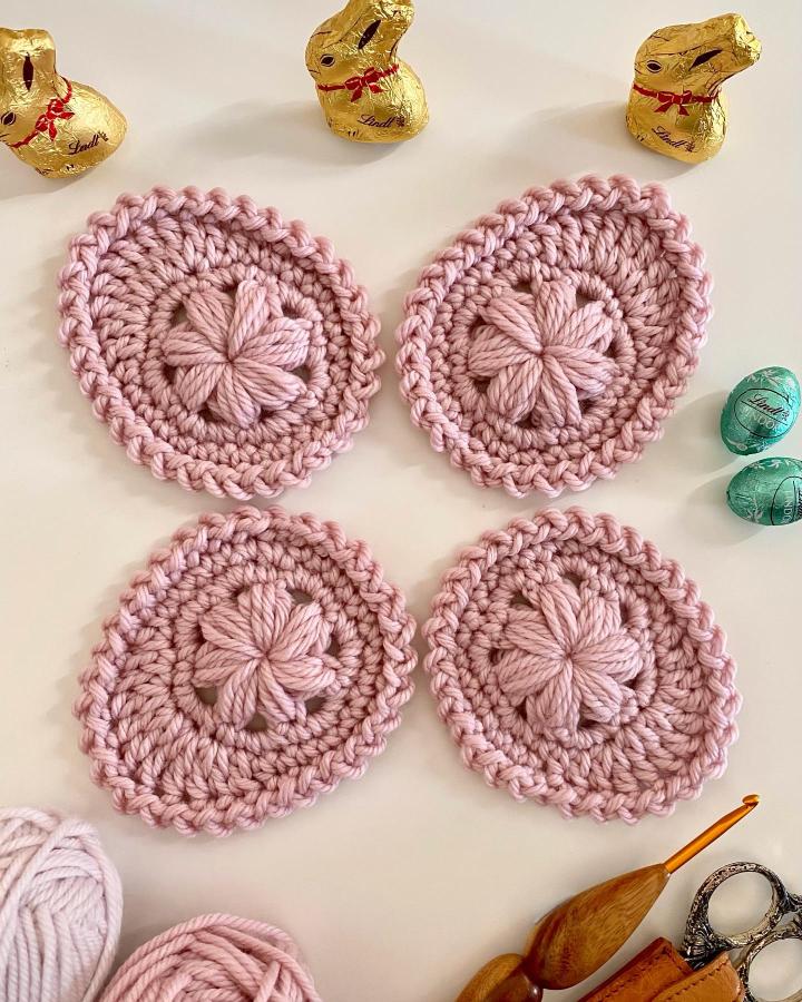 Dusty pink chunky yarn crochet eggs from @just_pootling with flower stitch detail for easter crochet ideas.