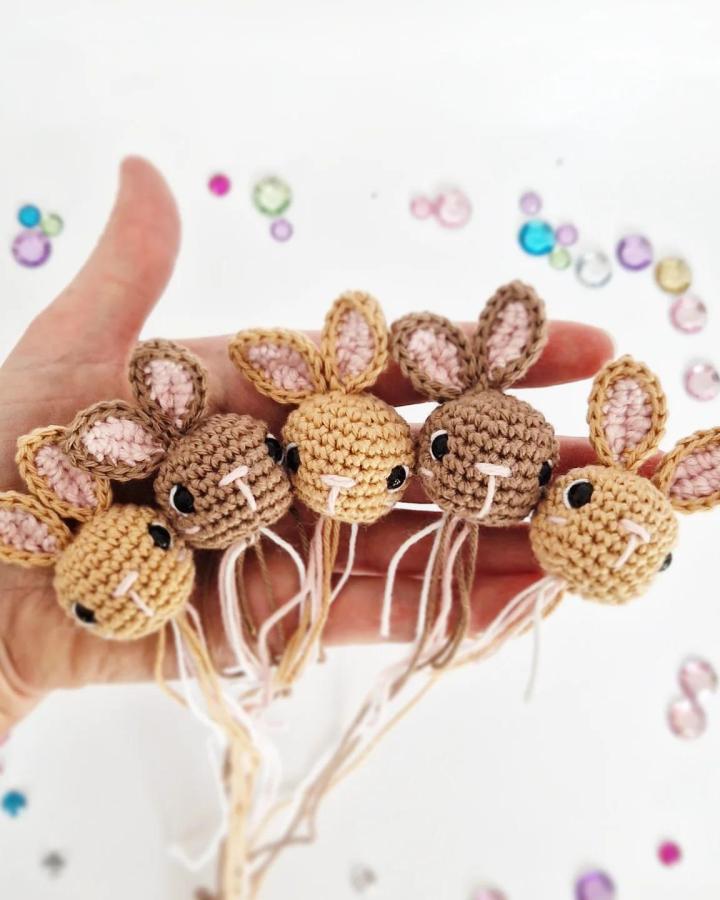 Handmade beige and brown miniature bunny heads crochet from @marvindesigns with pink ear details and black bead eyes perfect for easter crochet ideas.