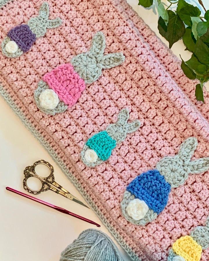 Pink crochet piece with colorful bunny appliqués from @seeloveshare featuring playful pastel hues and fluffy tails, easter crochet ideas.
