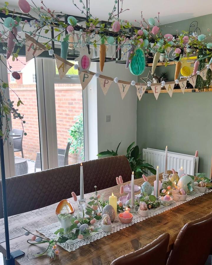 Pastel burlap garland and lace runner Easter table decor ideas by @new_spouse_new_house with eggs and candles on wooden table
