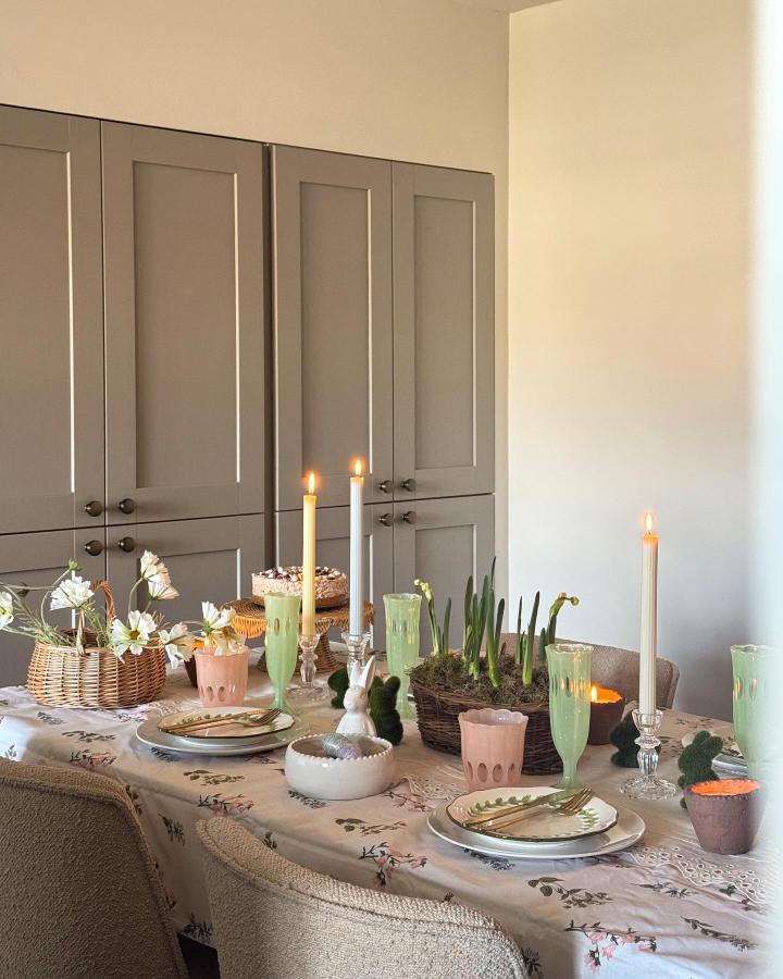 Light pastel Easter table decor ideas featuring greenery, wicker, candles, and floral details from @athomewithfran.
