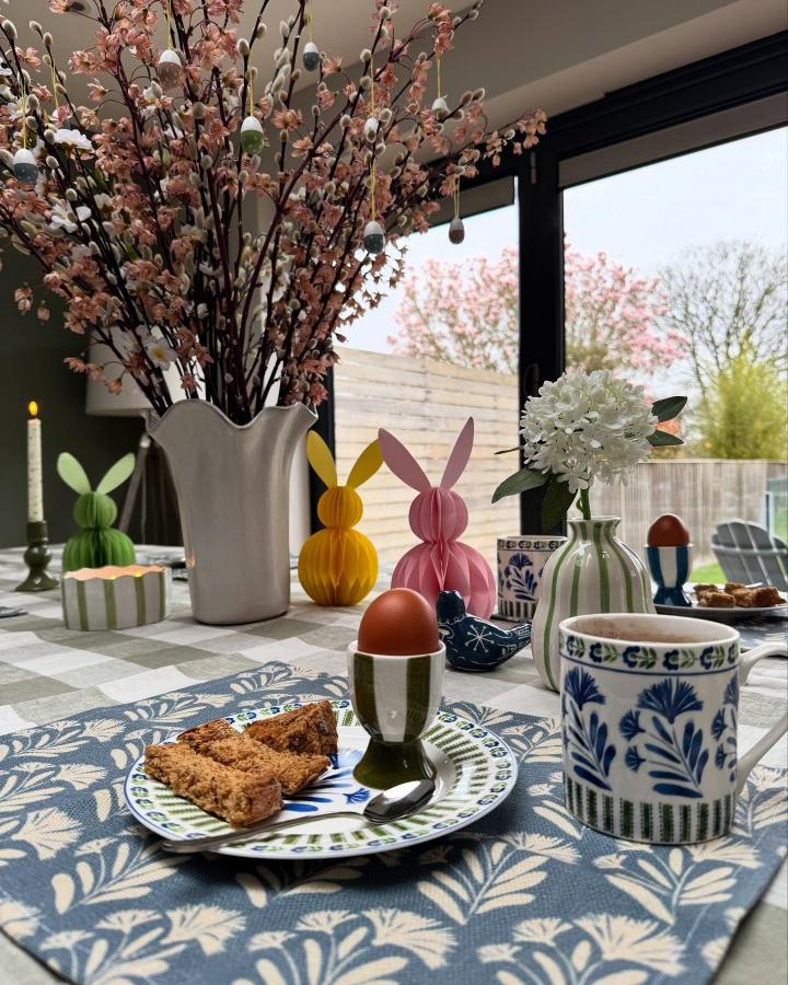 Playful paper bunny decorations on a floral and ceramic Easter table from @oakenhome with cozy pastels and natural light.