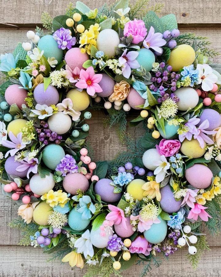 Colorful pastel Easter eggs wreath with flowers and greenery from @wyldewreath. Vibrant easter wreath ideas with soft spring tones.