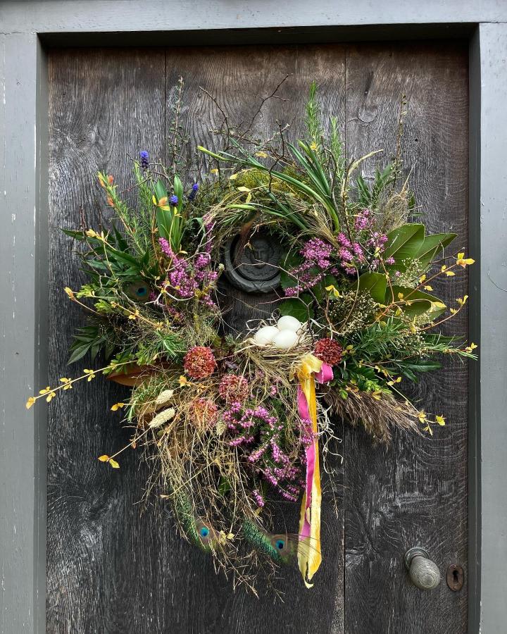 Natural mixed floral wreath with bird nest and eggs from @bespokeflowersbyhanna. Rustic earthy easter wreath ideas.