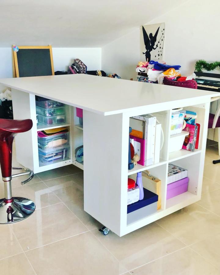 White modular ikea kallax desk hacks & ideas from @alazros with rolling storage cubbies beneath a spacious white desktop.