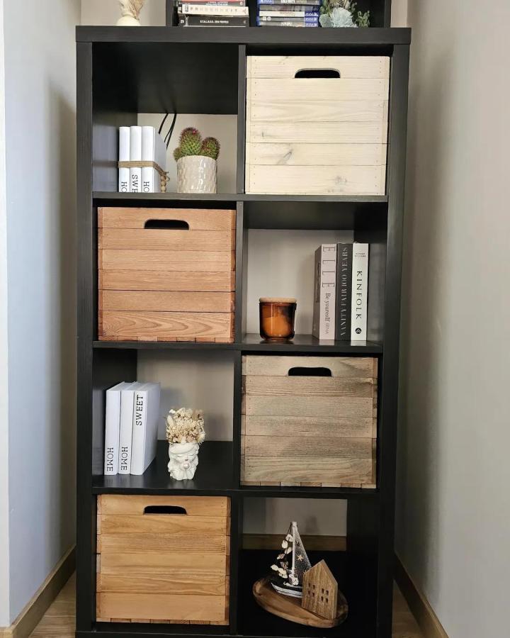 Black Ikea Kallax shelf with natural wooden crates from Premiumwoodencrates showing rustic ikea kallax dresser hacks & ideas.