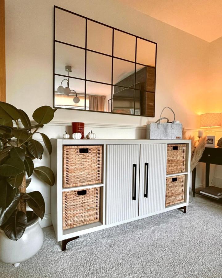 White textured door Ikea Kallax dresser with woven baskets and black handles from @lifeatlangdale in cozy living space