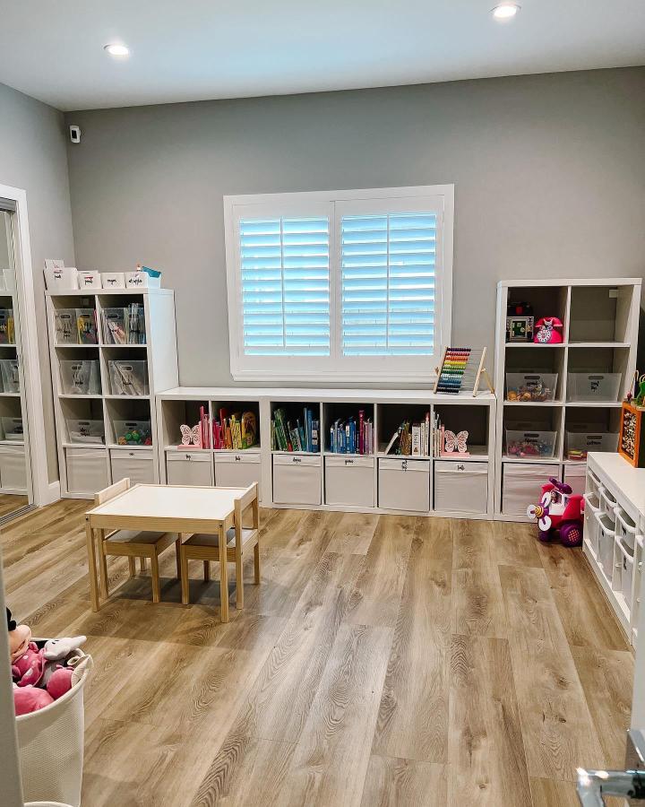 White and natural wood ikea kallax playroom hacks & ideas with low storage bench and kid’s table from @beautifullifela. Organized, bright, and cozy space.
