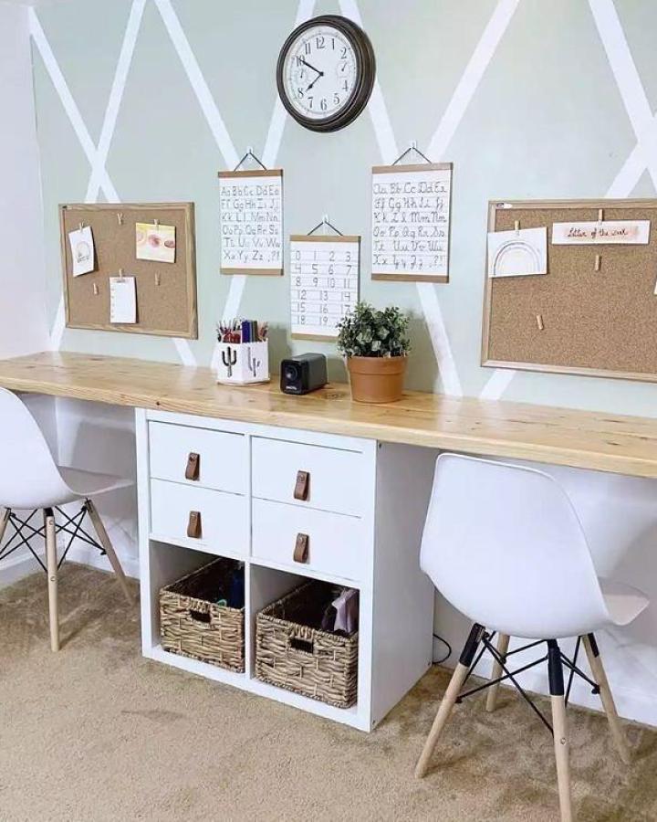 White Ikea Kallax playroom storage with leather drawer pulls and baskets under natural wood desk from @decoexpresspty. ikea kallax playroom hacks & ideas.