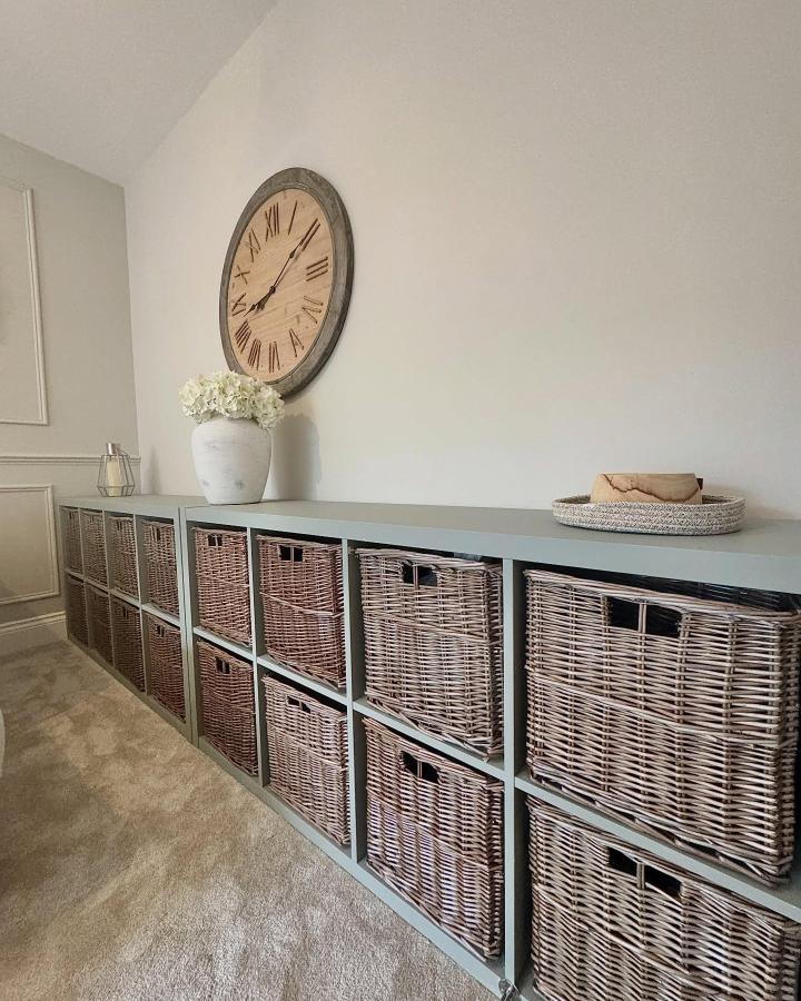 Muted gray Ikea Kallax tv unit with natural wicker baskets from @athomewitha.j soft storage and rustic charm in living space ikea kallax tv unit hacks & ideas