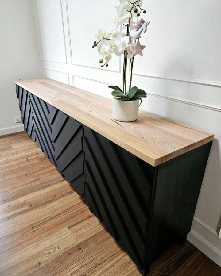 Black geometric textured ikea kallax tv unit with natural wood top from @roseluxuryfurniture. Modern and bold living room furniture idea.