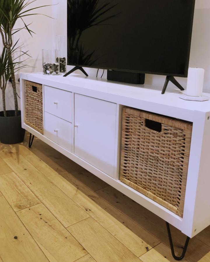 White and natural wicker Ikea Kallax TV unit hacks & ideas with black hairpin legs from @lifeinsuffolk__ in cozy living room setup.