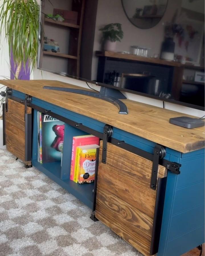 Blue painted Ikea Kallax TV unit with sliding rustic barn doors and wood top from @do.it.yourself.mum. Storage and style combined.