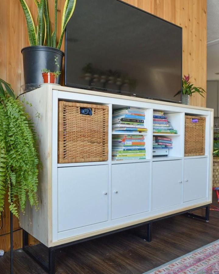 White Ikea Kallax TV unit with woven baskets and black metal legs from Madness Method featuring organized book storage and natural textures ikea kallax tv unit hacks & ideas.
