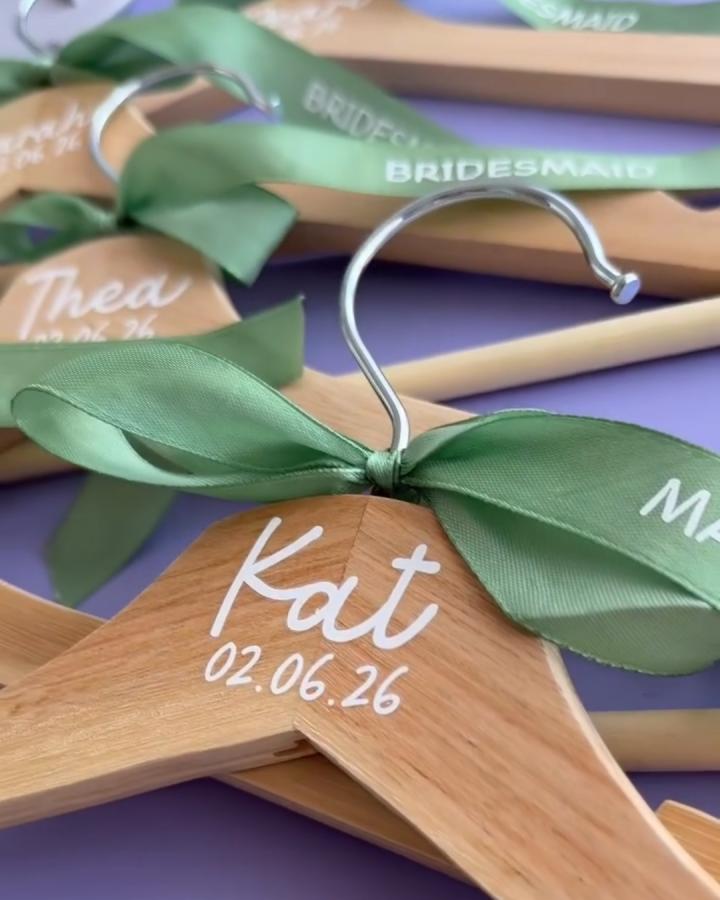 Natural wood coat hangers with green ribbon and white lettering from @caitycraft for ikea wedding hacks & ideas. Personalized bridal party hangers.