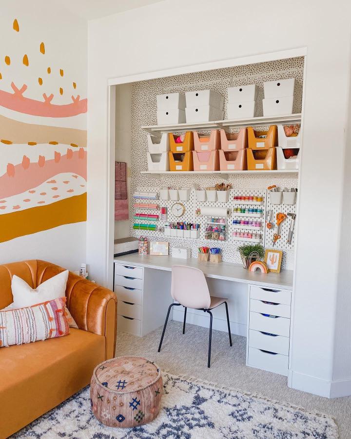 White and orange pegboard craft closet from @rebeccadiy. Bright bins and tidy desk storage.