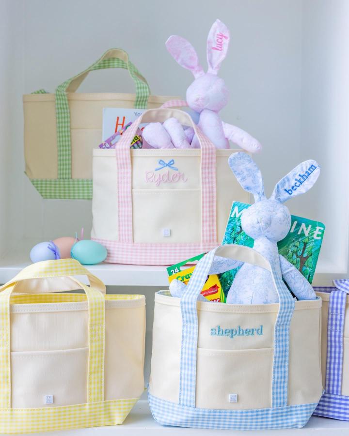 Light pastel gingham trimmed canvas totes from @cfazeldesigns filled with Easter basket ideas including plush bunnies and books.