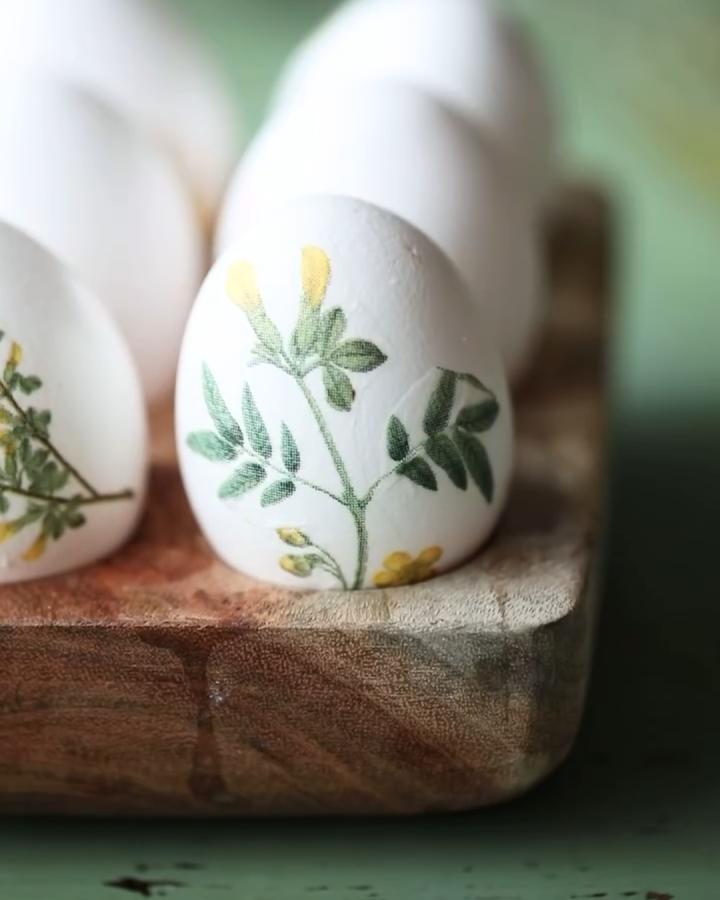 White eggs decorated with delicate green and yellow botanical decoupage from @ottiliaorenius. Easter egg decorating ideas for adults with nature-inspired prints.
