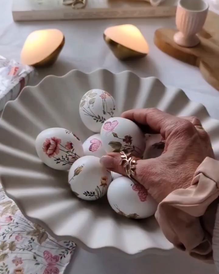 White eggs with soft pink and green floral transfers in a scalloped bowl from @herzenstimme showing elegant easter egg decorating ideas for adults.