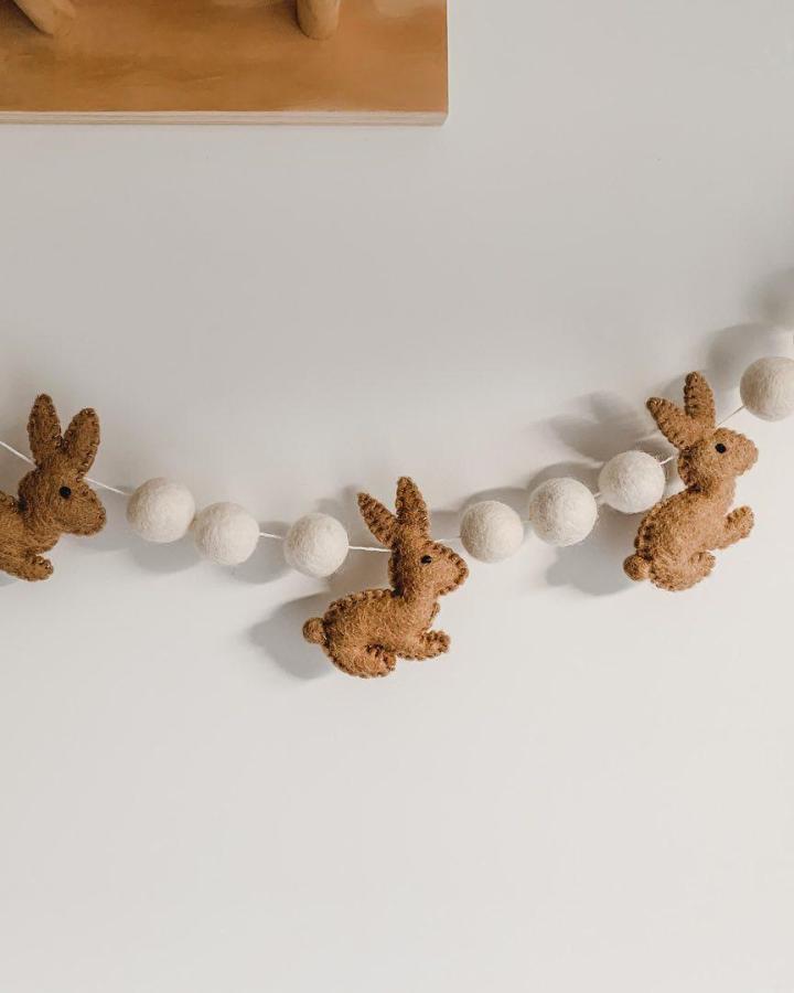 Brown felt bunnies and white felt balls Easter garland ideas from @store17.sumner, cozy and handcrafted decoration.