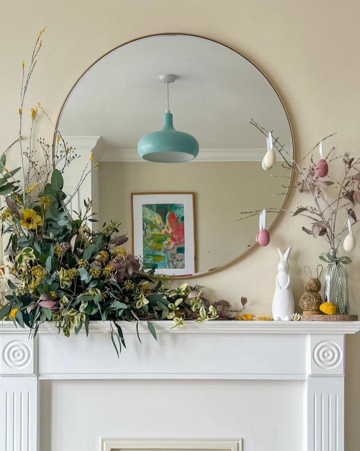White ceramic bunny and natural greenery with pastel eggs Easter mantel decor ideas from Hobbycraft. Simple and elegant spring mantel display.