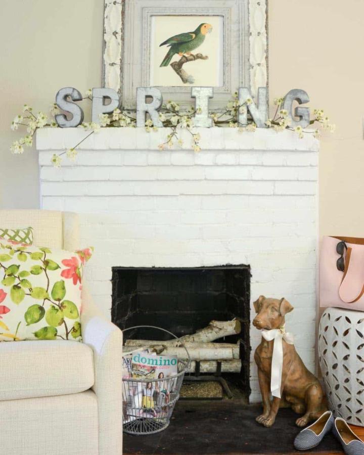 Galvanized metal letters and white blossoms on a mantel from Iron and Twine showing easter mantel decor ideas.