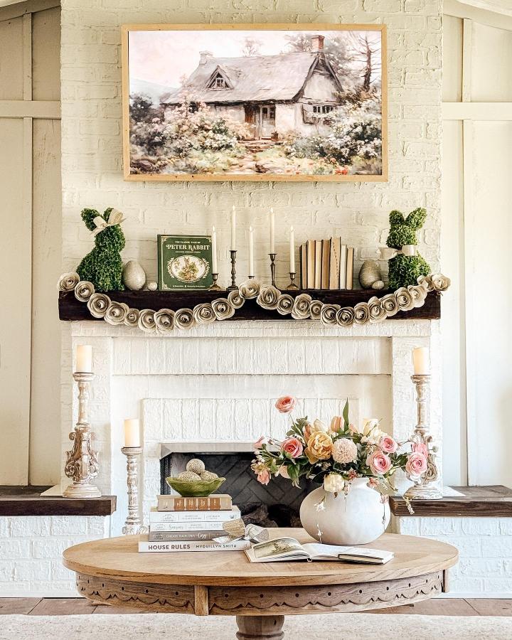 Green moss topiary bunnies and rustic garland mantel decor from @returninggrace with vintage book and soft candlelight for easter mantel decor ideas