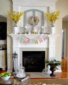 pastel egg wreath with yellow flowers and bunny accents on white mantel from Adventures in Decorating with easter mantel decor ideas