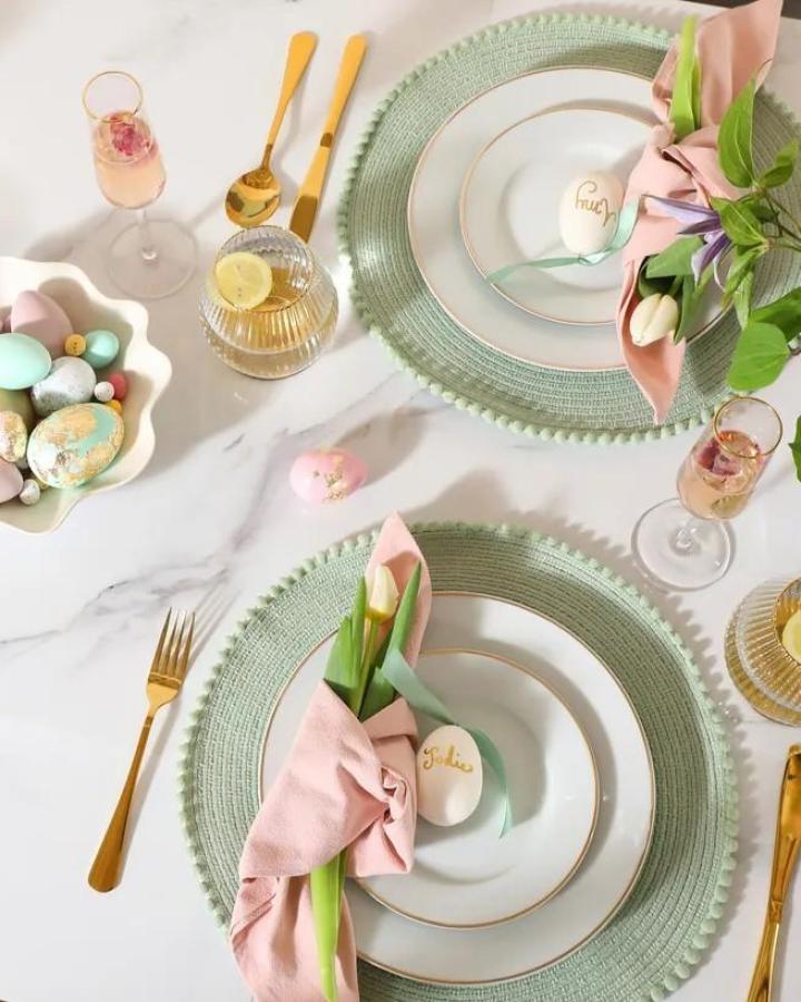 Pastel-colored elegant table setting with gold accents and personalized eggs from Furniture & Choice for easter place setting ideas.
