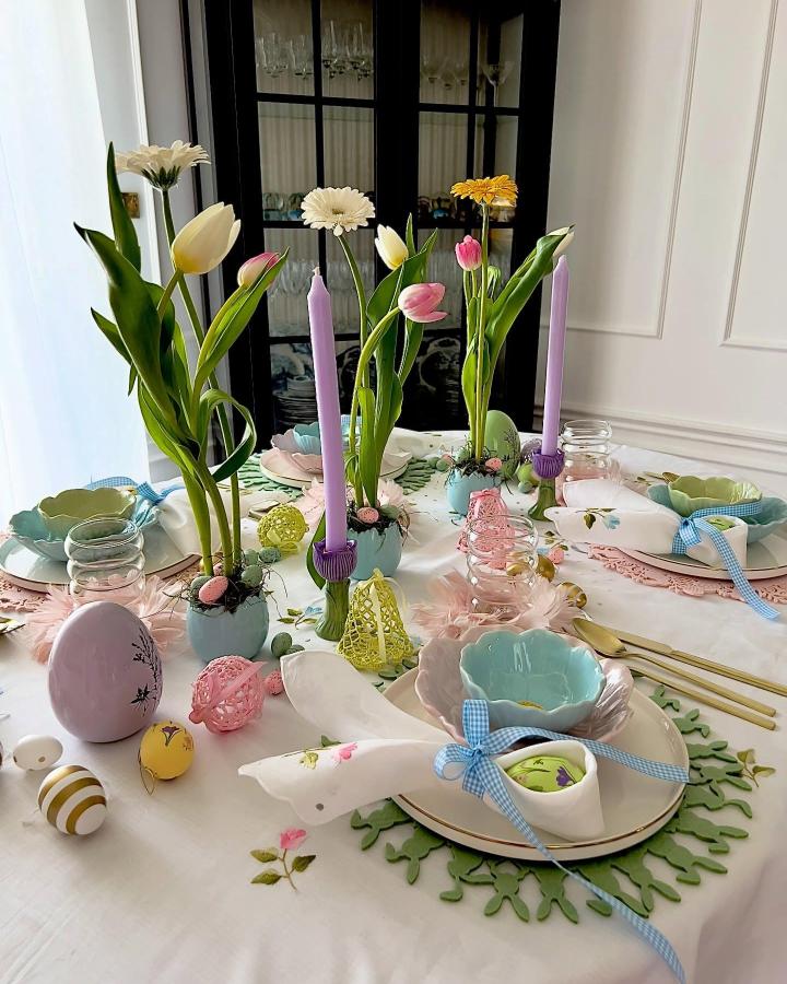 Soft pastel tulips and candles on a decorated Easter table from @noa_nene_home with charming bowls and ribbons.