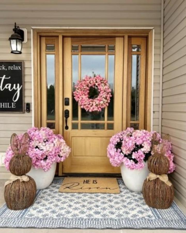 Pink hydrangeas in white pots with woven bunny accents on a porch inspired by @ourwintonhome for easter porch decor ideas.