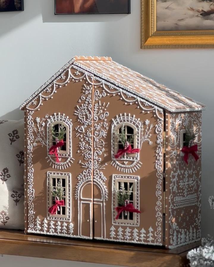 brown wooden gingerbread style dollhouse from @blushingembers decorated with white detailing and red velvet bows