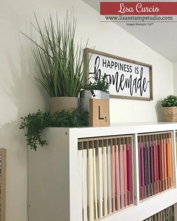 white Kallax unit with vertical color-sorted cardstock storage and small plants on top from Lisa's Stamp Studio ikea kallax craft room ideas
