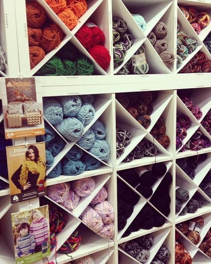 White Kallax cube storage with diagonal dividers filled with colorful yarn balls ikea kallax craft room ideas from @allaboutami. Neatly organized and visually appealing.