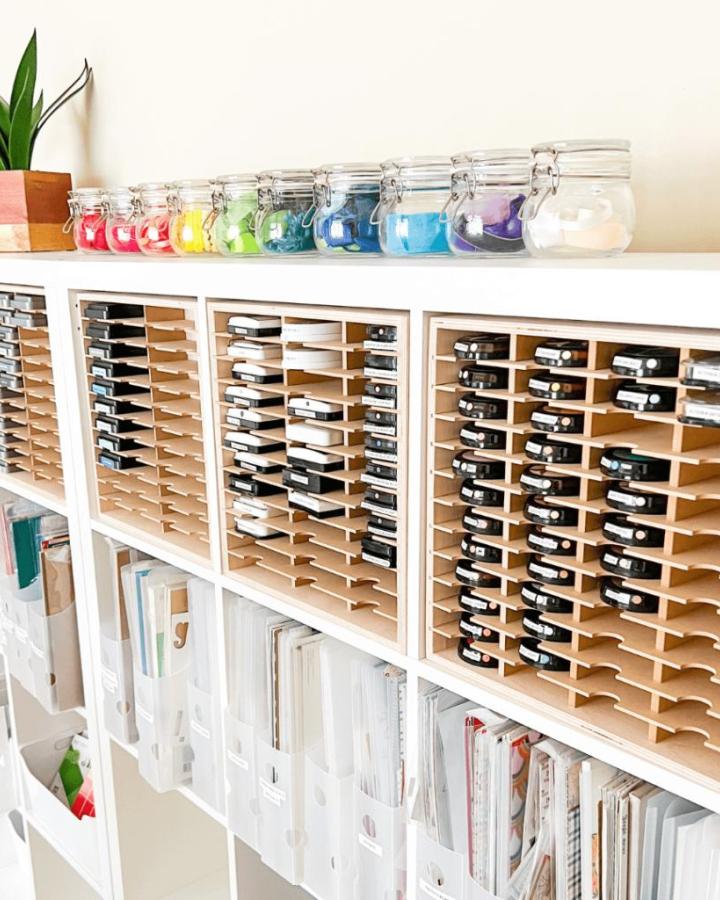 Rainbow glass jar display on white Ikea Kallax craft room ideas shelving with wooden divider inserts for stamp storage from Nicki Hearts Cards.