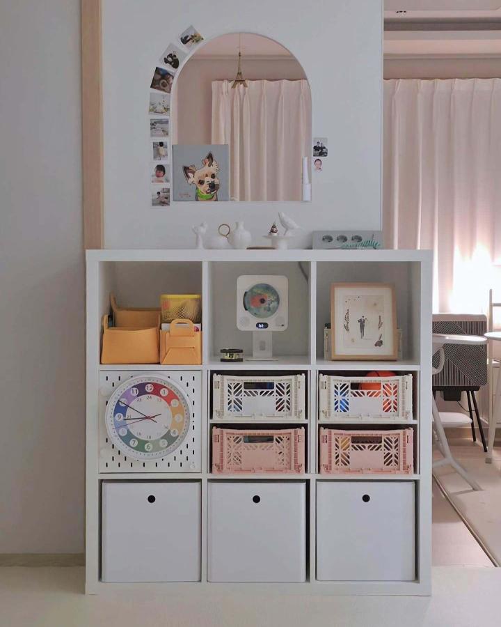 white and pastel Kallax storage unit from @kimddorong.zip. tidy toy cubbies with framed art and bins
