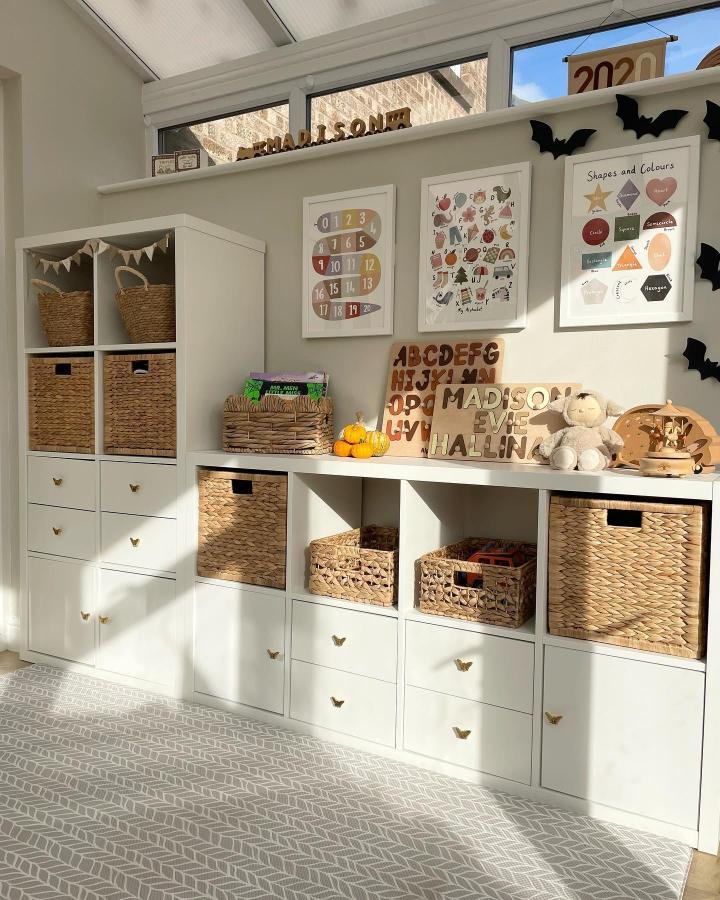 white and natural kallax toy storage from @life.with.madison.evie. Butterfly knobs and woven baskets, cozy kids room.