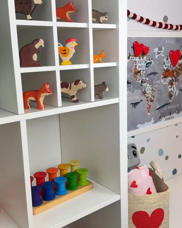 white Kallax toy shelf from @playroominspo. rainbow peg toys and animal figures in tidy cubbies, ikea kallax toy storage ideas.