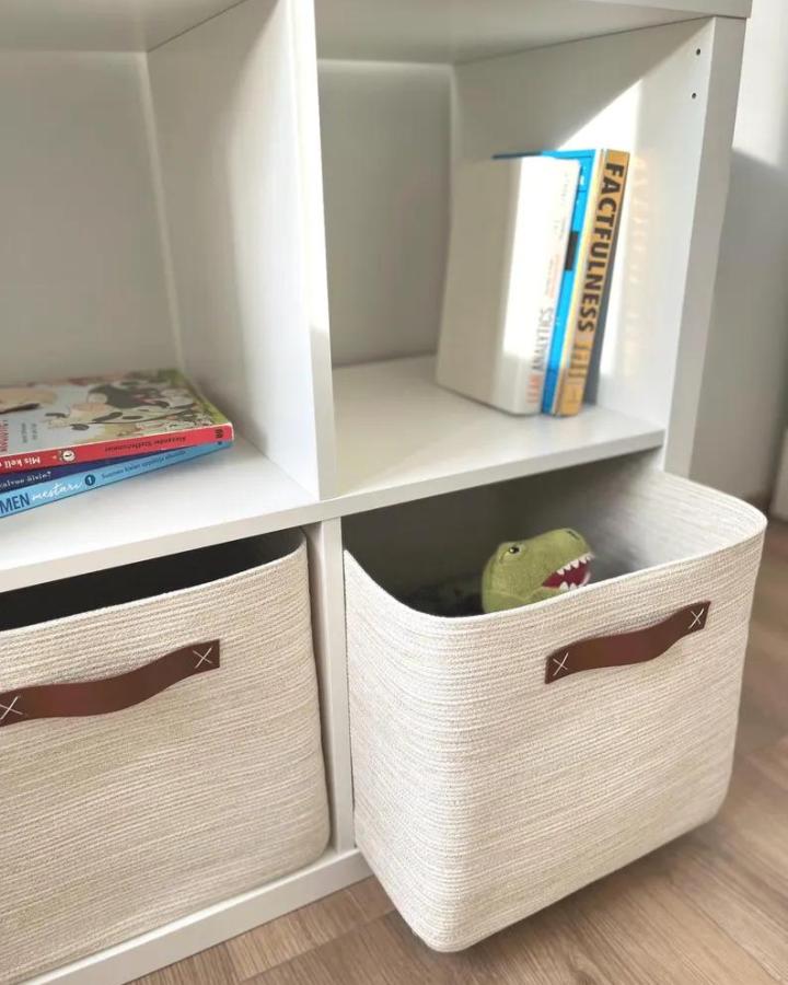 cream cotton toy storage baskets from LakkaHome. Kallax shelf with rounded bins and toy books.