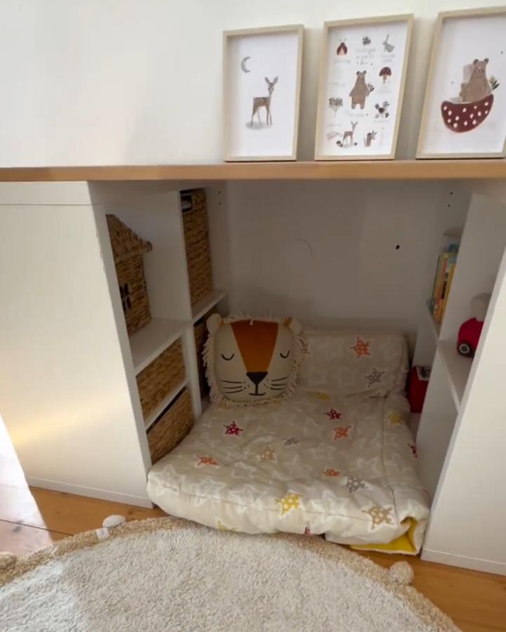 white and wood kallax nook from @kreativbabs. cozy toy storage with baskets, floor cushion, and framed art.