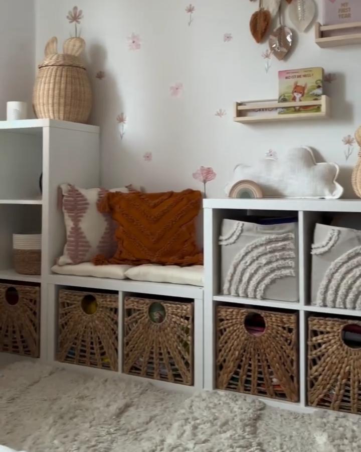 cream and woven toy storage from @mej_hyggehome. Cozy Kallax cubes with natural baskets and soft cushion seating in a playroom.