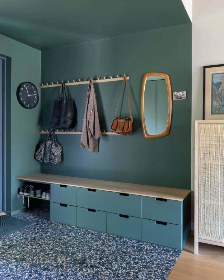 painted green Nordli base cabinet and wooden bench top storage bench from @atriumhus_1971 in a stylish entryway with hanging pegs and green walls