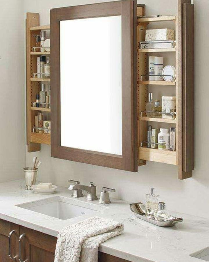 Wood framed bathroom mirror with hidden pull-out shelves from Homestetik. Space-saving and stylish bathroom mirror ideas for small spaces.