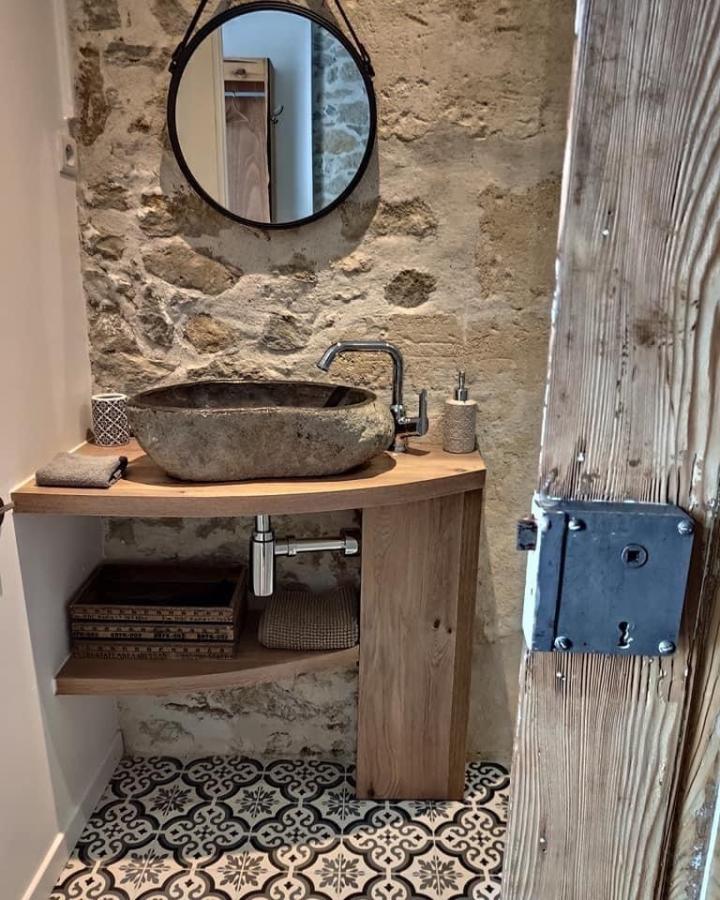 Natural stone sink and wood counter with hanging round mirror in small bathroom by @les_sequoias. Cozy rustic style bathroom mirror ideas for small spaces.