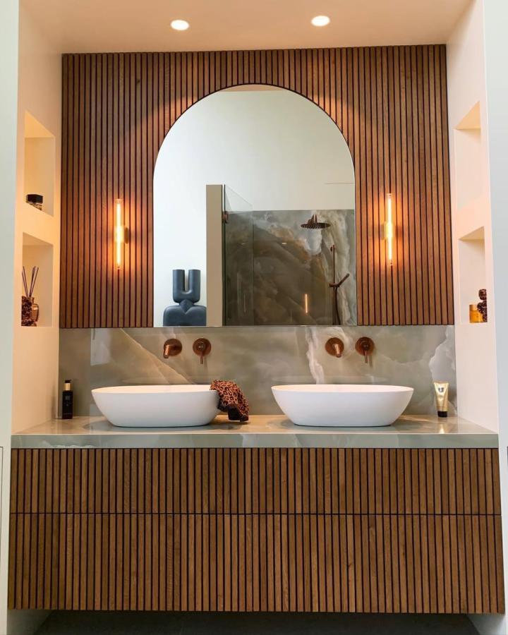 Vertical wood slat panels bathroom wall panel ideas from @maison_maillard_ with warm textured design and natural stone backsplash reflection.