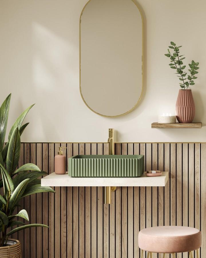 Light wood vertical slat bathroom wall panel ideas with green sink and gold fixtures from @naturepanel_uk creating cozy warmth.
