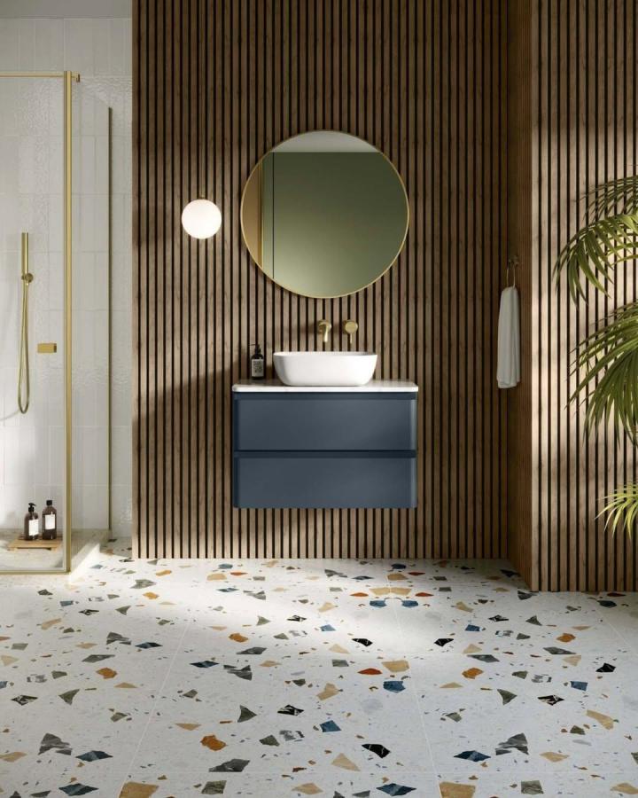 Warm wood slat paneling bathroom wall panel ideas from @wallsandfloors with blue vanity and terrazzo flooring creating texture and warmth.